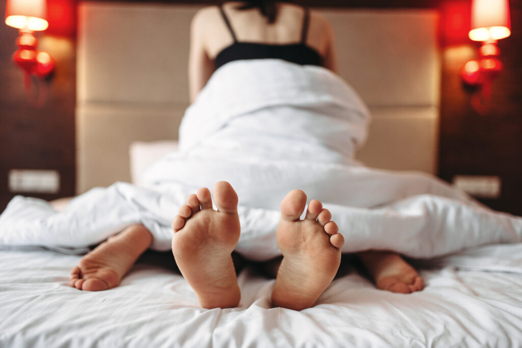 Woman sitting on man, intimate games in bed